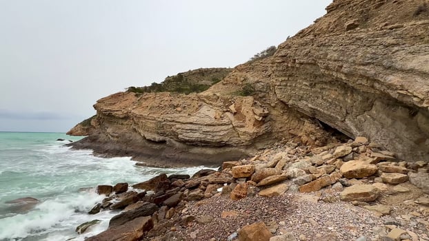A beautiful and scenic Rocky Beach adorned with stunning turquoise waves rolling under cloudy skies photo