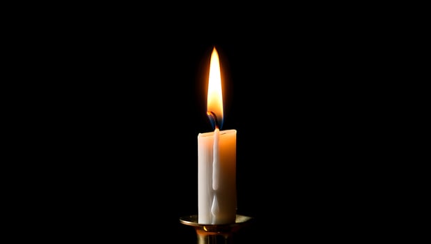 Elegant Candlelight on Dark Background Representing Hope Remembrance and Warmth with Bright Flame Illuminating Serenity and Peace photo