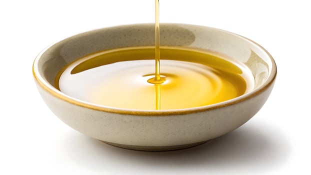 Golden liquid pouring into a ceramic bowl photo