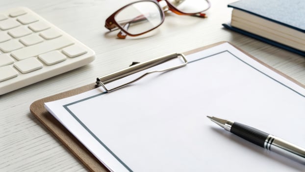 Clipboard, pen, paper, and eyeglasses on office desk create professional and organized workspace atmosphere photo