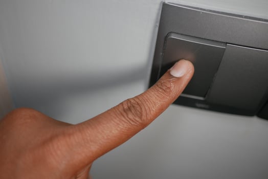 Finger pressing a light switch in a home setting photo