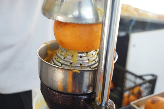Fresh orange juice being squeezed at a street market stall photo