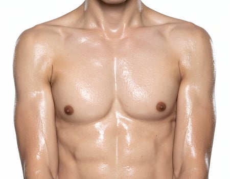 close up of male torso and shoulders with wet glistening skin after water-based skin treatment on isolated white background photo