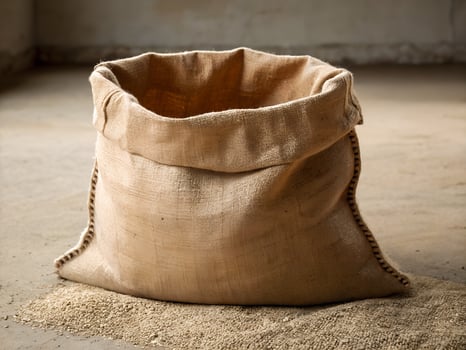 Beige Burlap Sack of Grain on Concrete Floor photo
