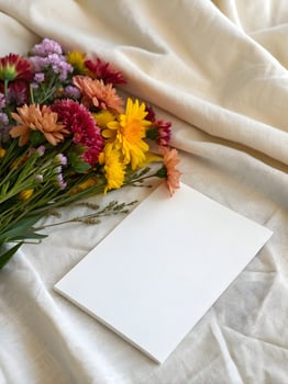 Blank Card with Colorful Flowers on Soft Fabric Background Mockup photo