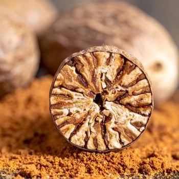 Detailed Macro Shot of Sliced Nutmeg with Ground Powder on a Dark Background photo