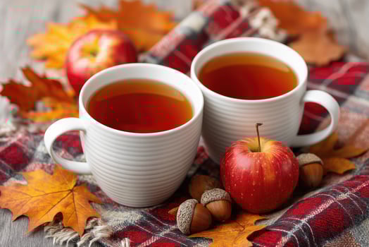 Two white mugs of hot tea, apples, acorns, and autumn leaves creating cozy atmosphere photo