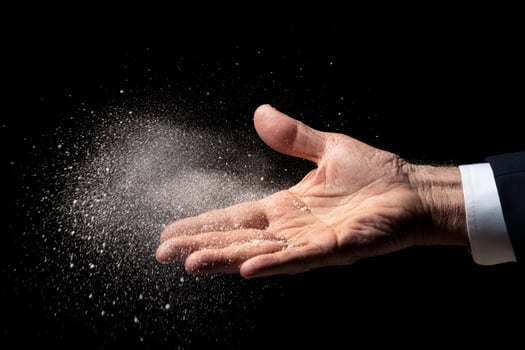 A man in a suit is holding a white powder photo