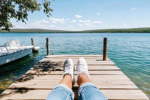 A person sitting on a dock with their feet on the edge photo