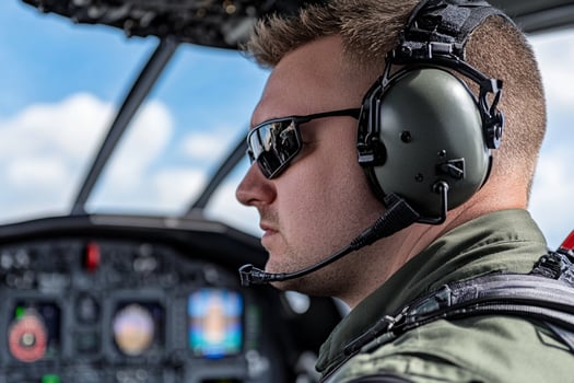 A man wearing headphones and a headset in a plane photo