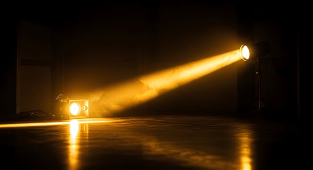 Dramatic golden spotlight illuminates smoky atmosphere, creating vibrant, energetic scene for events or performance photo