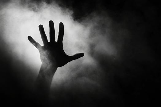 A hand is shown in the smoke of a foggy room photo