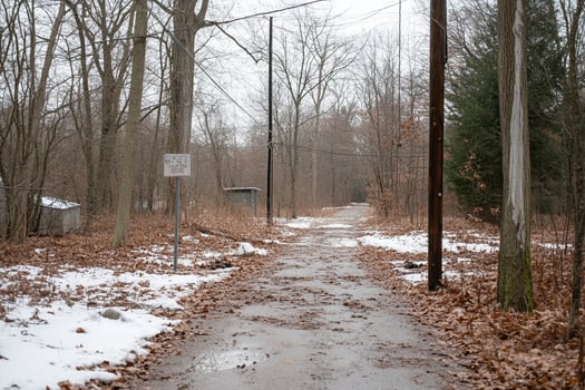A road with a sign on it and trees in the background photo