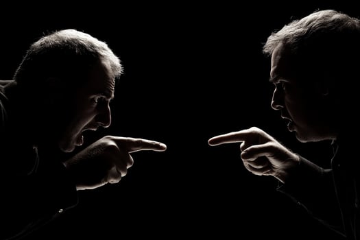 Two men pointing at each other in silhouette photo