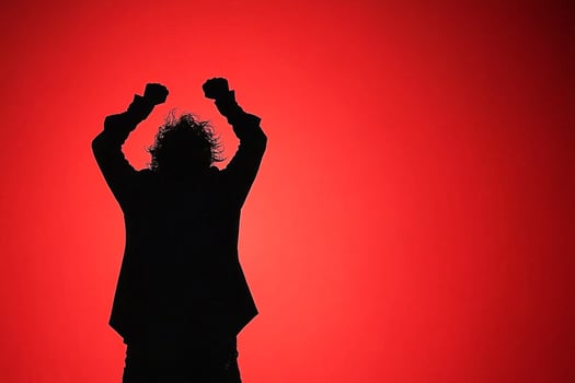 A silhouette of a man with his arms up in the air photo