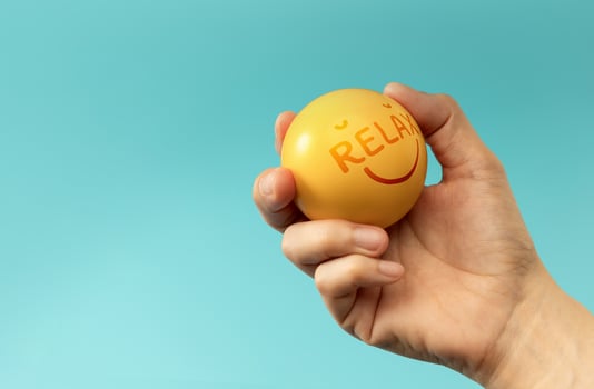 Hand holding Stress ball labeled Relax used for emotional control and mental health practice, helping reduce tension and improve mood photo