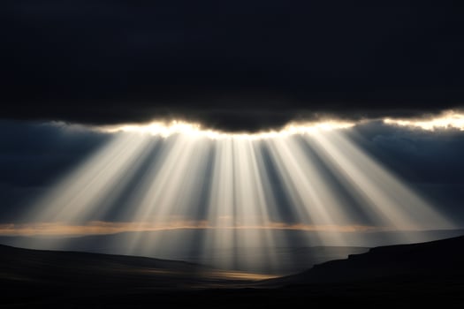 Sunbeams shining through clouds over a valley photo