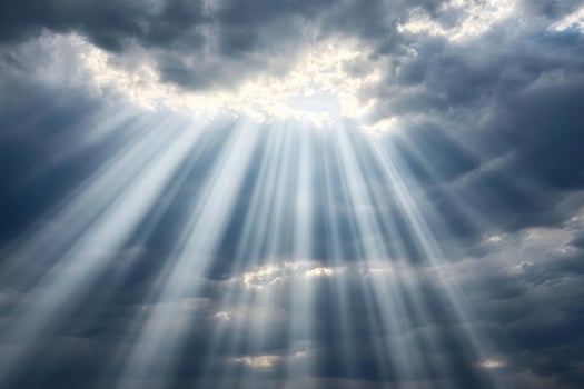 Sunbeams shining through clouds in a dark sky photo