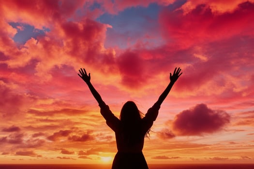 Woman with arms up in the air at sunset photo