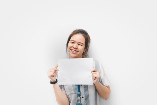 Asian woman holding a blank paper up to her face photo