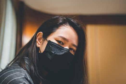A woman wearing a black face mask photo