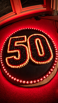 Fifty years celebrated with glowing cake and festive red lights. photo