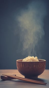 Steaming Bowl of Rice with Chopsticks on Wooden Table. photo
