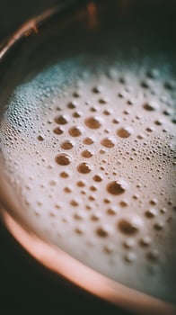 Close up of foamy beverage with warm, glowing light and soft bubbles. photo