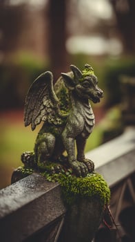 Stone Gargoyle Statue Covered in Moss on a Rainy Day. photo