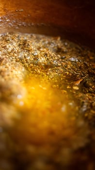 Close up of aromatic herbs steeping in warm liquid with golden light. photo