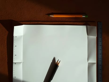 A pencil and paper on a desk with a ruler photo