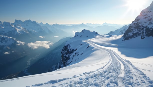 Snowy Mountain Range with Vehicle Tracks and Clear Sky photo