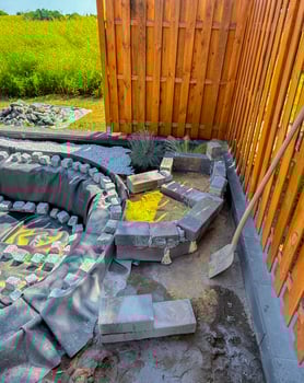 finishing a pond in the garden, surrounded by stones to make a natural pond photo