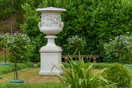 A white vase in a garden photo