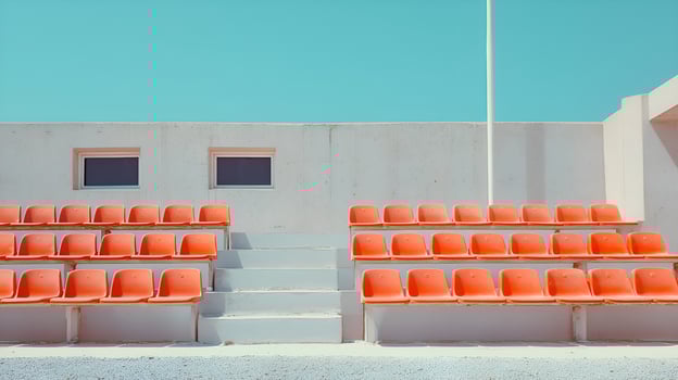 Empty orange seats waiting in a deserted stadium under blue sky photo