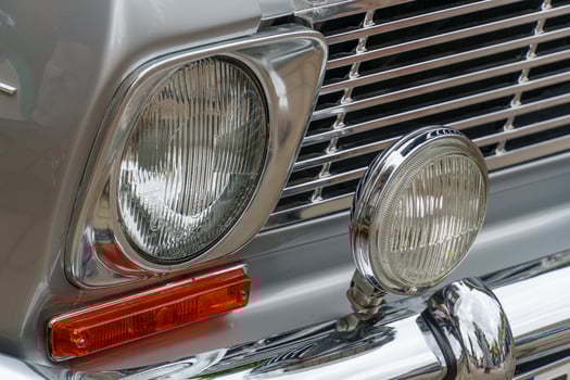 A close up of a car's front end with a light photo