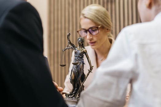 Lawyer discussing legal services with clients, featuring a statue of Lady Justice, symbolizing resolution and fairness in legal disputes and negotiations for effective outcomes photo