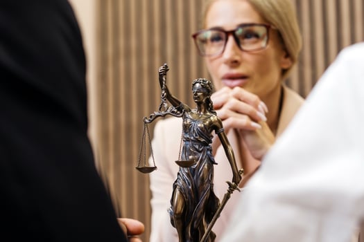 Lawyer discussing legal services with clients in office, featuring Lady Justice statue symbolizing fairness and resolution in disputes, conveying professionalism and trust photo
