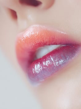 Tropical ombre lips close up with glossy pink, red, and dark purple layers, emphasizing texture and rich color transition, editorial beauty detail photo
