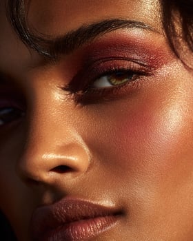 High detail cheek portrait of Indian woman featuring dramatic ombre blush in gold, ruby red, burnt orange, and deep rose, luminous texture, soft blur photo