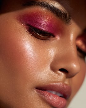 Hyperreal beauty shot of Indian skin with vibrant ombre blush in hot pink, cherry red, bronze, and amber hues, set against white dreamy blurry background photo