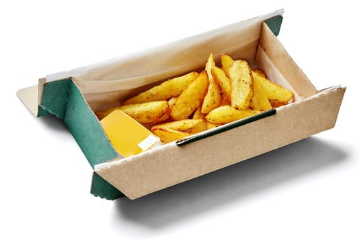Cardboard box containing seasoned potato wedges and cheese dip on white background photo