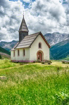 Small church standing on a green meadow, Italian Alps photo