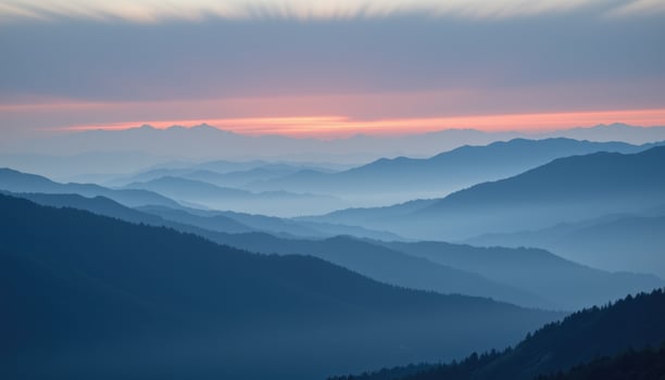 Serene Mountain Landscape with Layers of Blue and Soft Pink Sunrise Over the Horizon photo