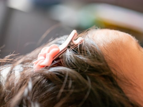 Newborn baby's hair accessory close-up family home intimate moment cozy indoor setting parental love concept photo