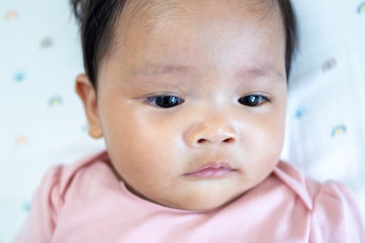 Newborn baby girl asian infant close-up portrait soft lighting gentle look for family memories photo