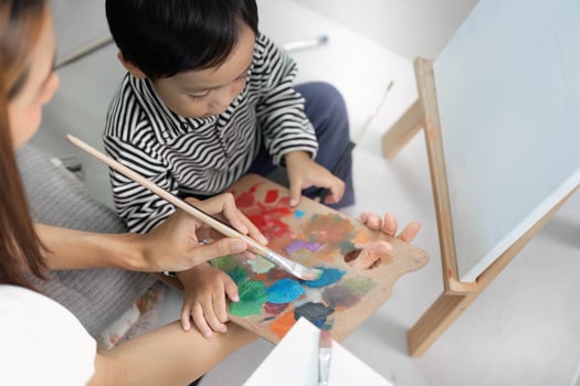 Mother Assisting Child with Color Mixing in Art Class photo
