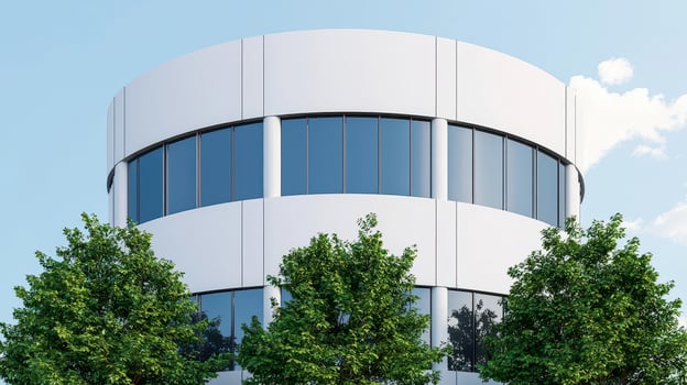 Modern office building with large windows and greenery in the foreground. photo
