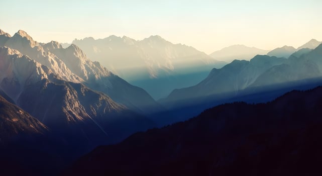A mountain range with sun rays shining through the clouds photo