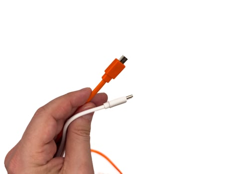 USA type C, USB type A, micro usb, chargers, type c, white usb, orange usb. A hand holding two different colored cords photo